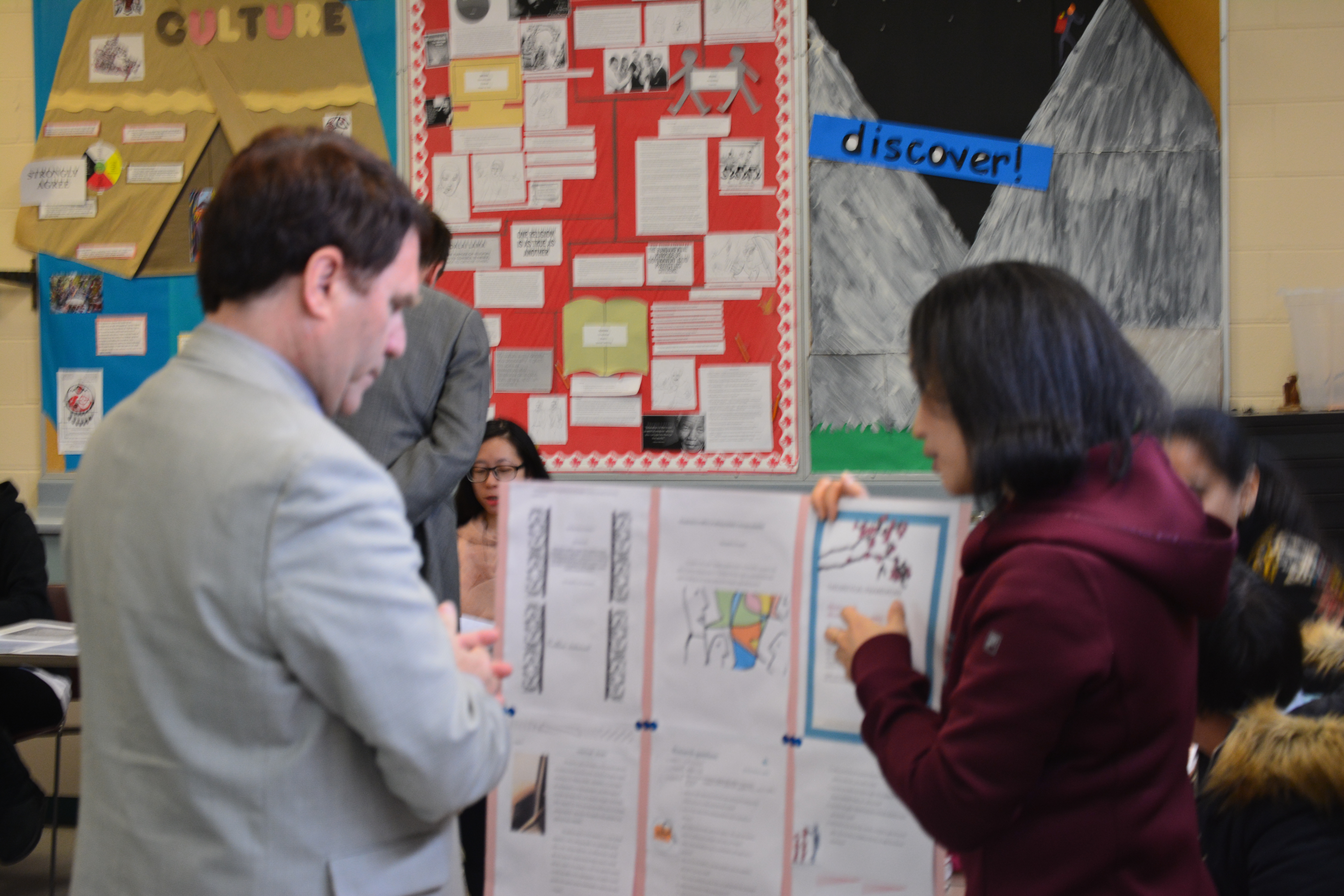 Dr. Smith listening to a Vicki Ai, an international graduate student in Research in Education , explain her research poster